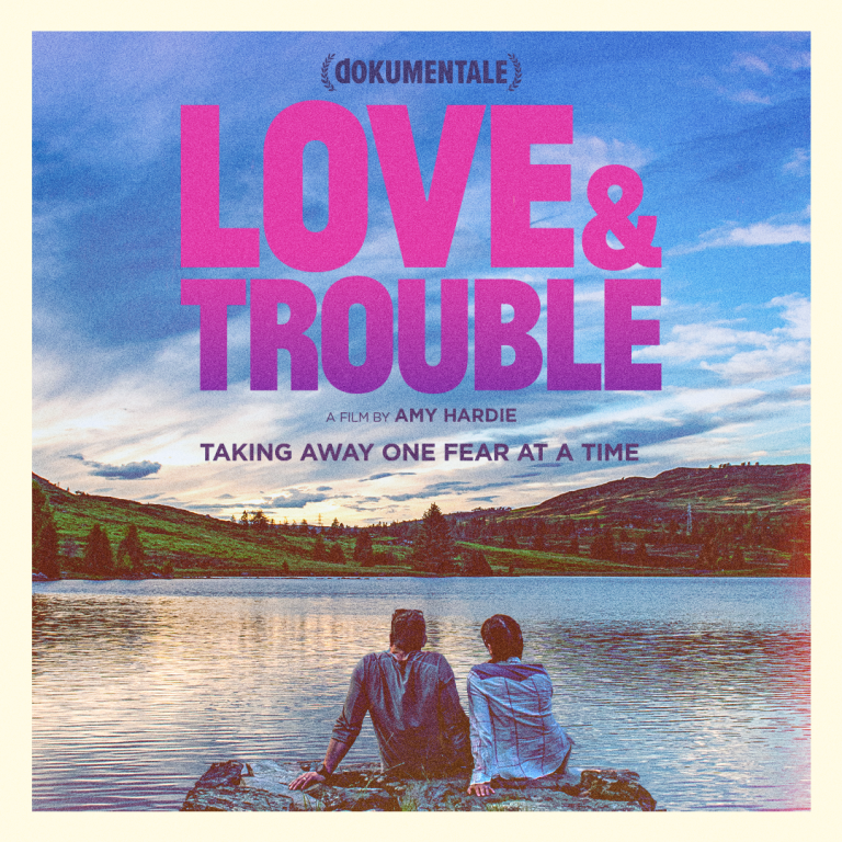 Poster for Love and Trouble featuring a couple with their backs to us, looking at a beautiful lake